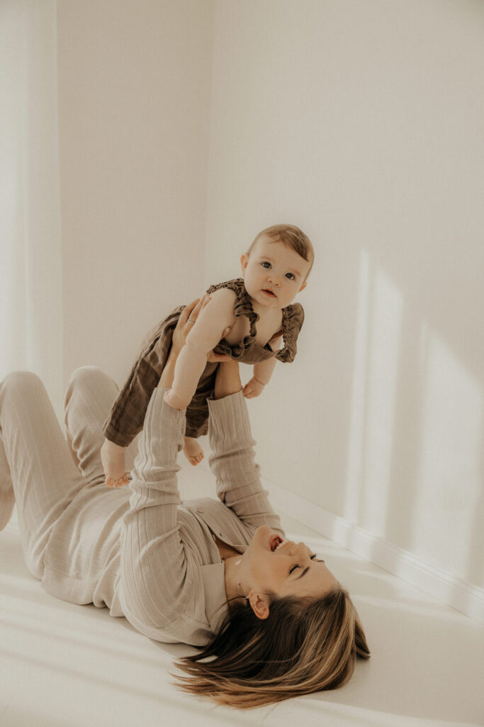 Mama und Kind kuscheln und spielen miteinander im Fotostudio